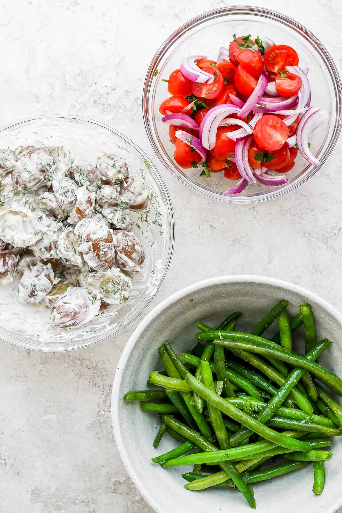 Different ingredients for a Nicoise Salad in bowls. 