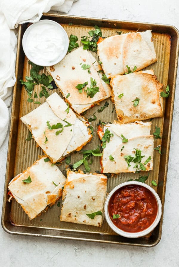 Sheet pan quesadillas that are topped with cilantro.