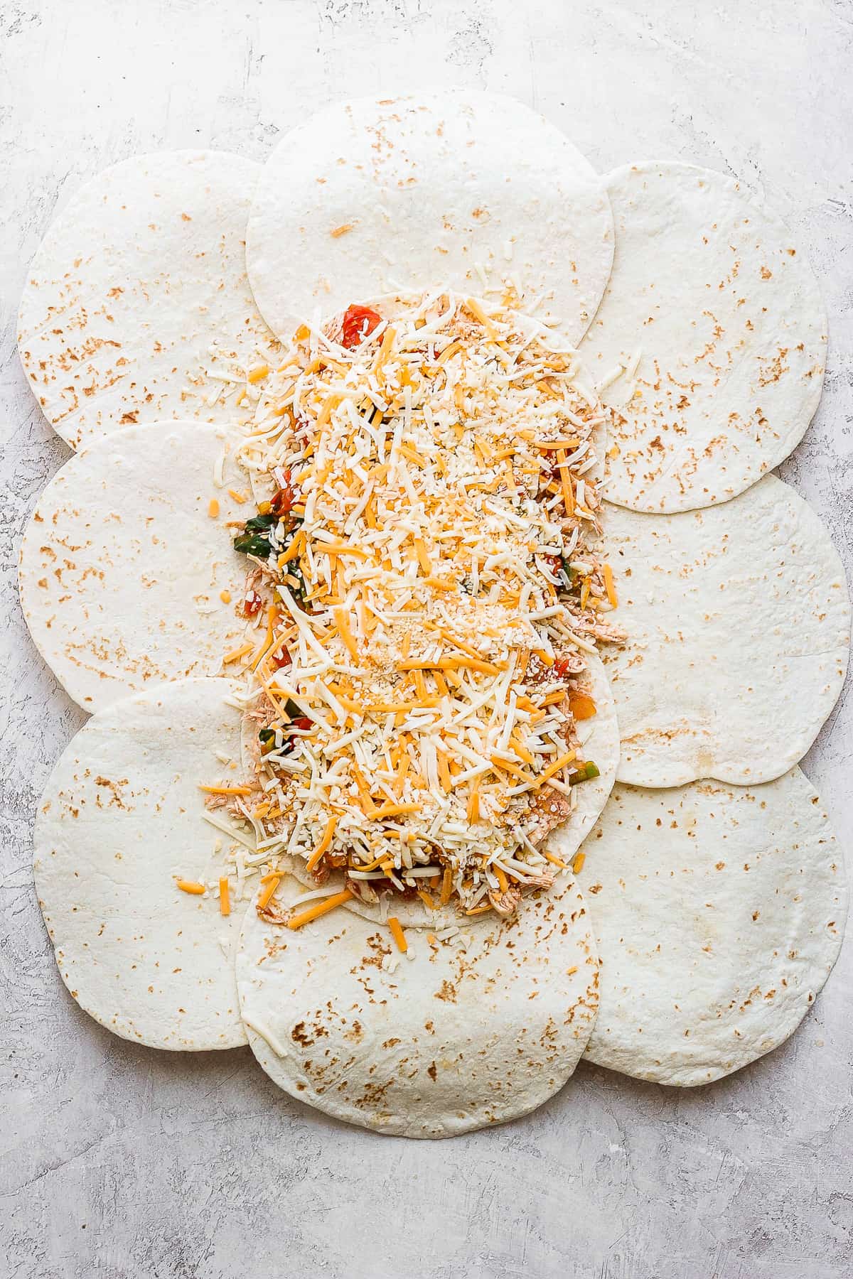 All the toppings for the sheet pan quesadillas on top of the tortillas.