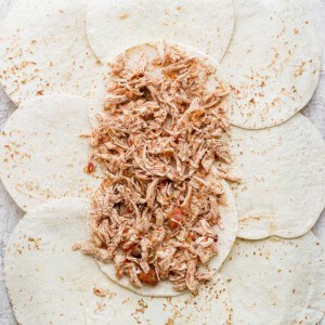 Shredded chicken on top of tortillas.