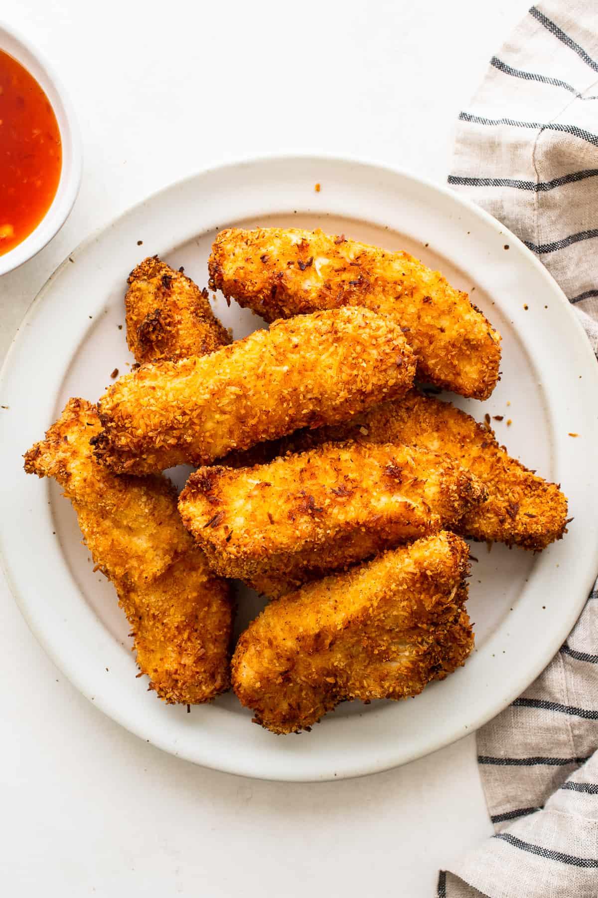 Crispy coconut chicken tenders on a plate.