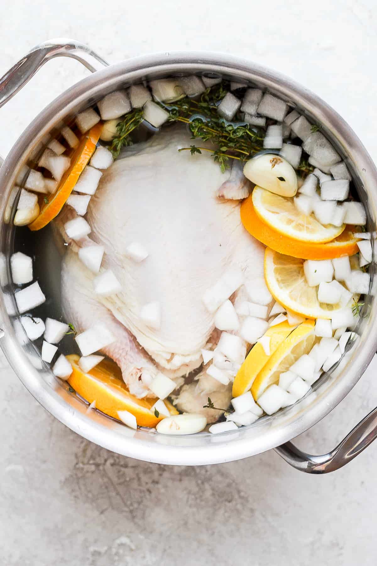 Chicken brine and a whole chicken in a pot.