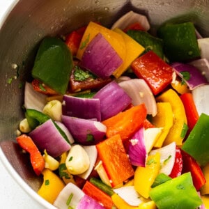 A bowl full of chopped peppers and onions.