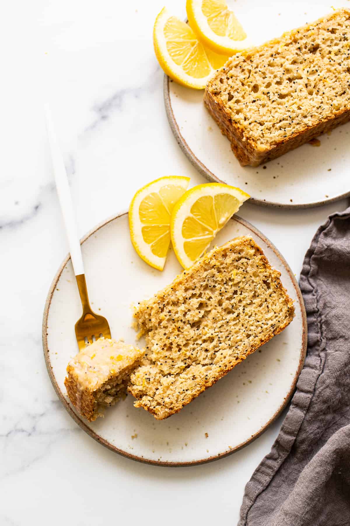 A piece of lemon poppy seed bread on a plate.