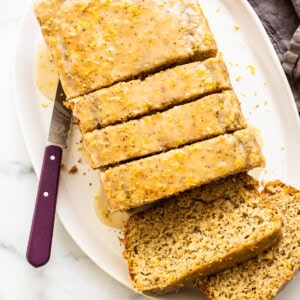 A sliced loaf of lemon poppyseed bread on a plate.