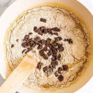 Chocolate chip cookie dough in a bowl with a wooden spoon.