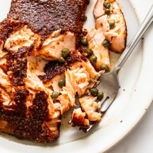 A piece of salmon on a plate with a fork.