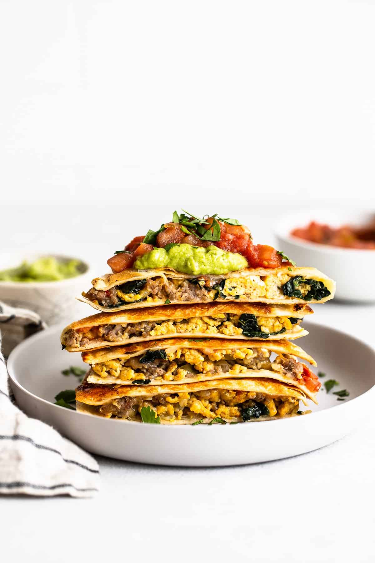 Freezer breakfast quesadillas stacked on a plate.