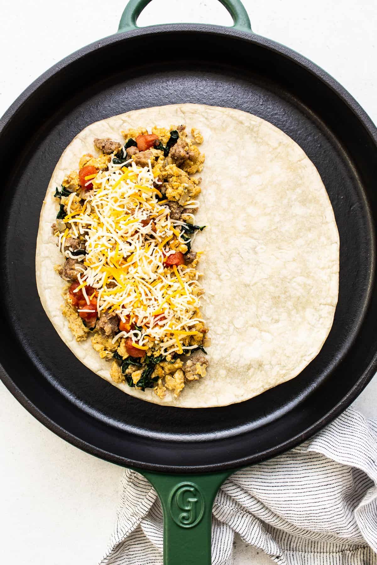 Breakfast quesadilla assembled in a cast iron skillet.