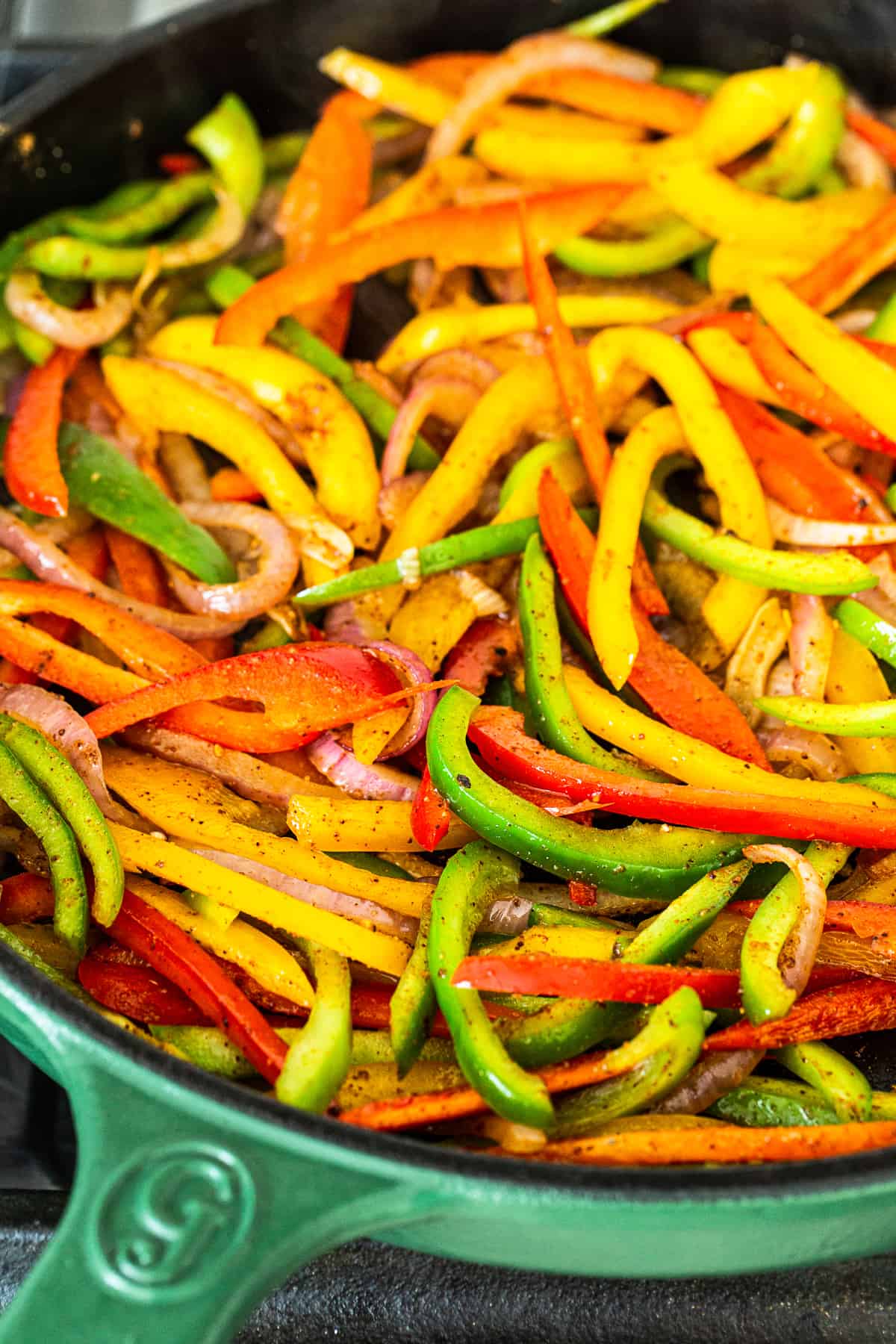 cooking peppers and onions in cast iron pan.