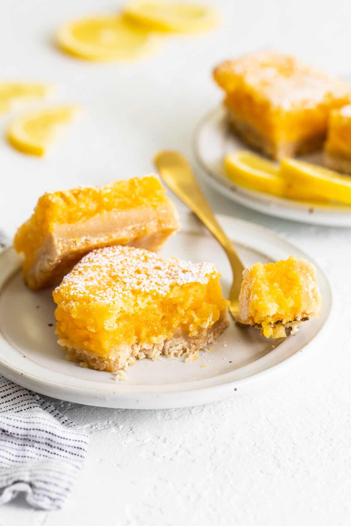 lemon bars on plate with fork.