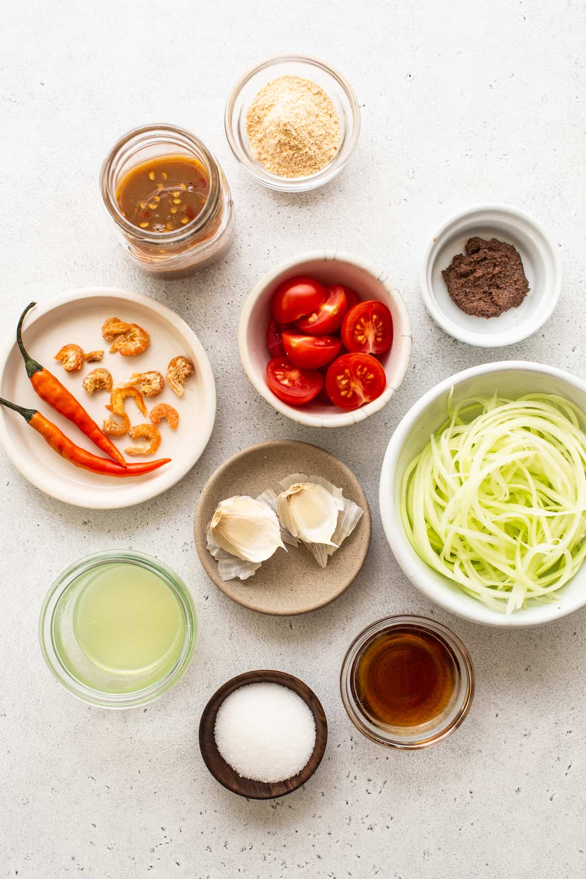 Ingredients for papaya salad in small bowls.