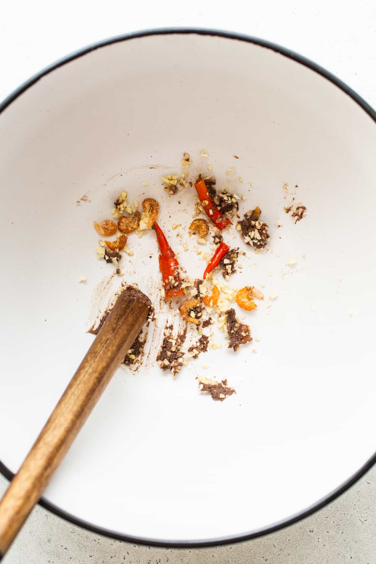 Thai chili peppers and dried shrimp being smashed.