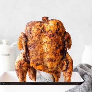 A beer can chicken on a baking sheet.