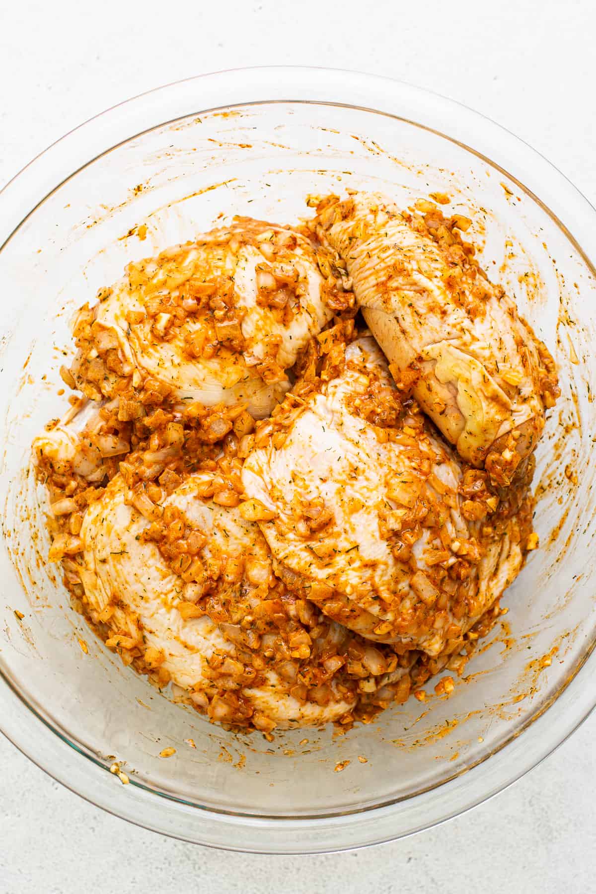 Chicken thighs marinating in a bowl.