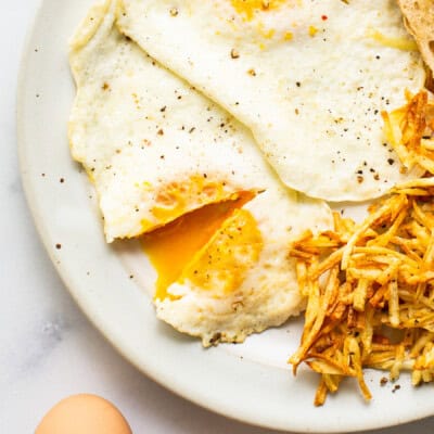 A plate with eggs, potatoes and toast.