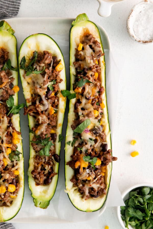 Three zucchini boats stuffed with meat and corn.