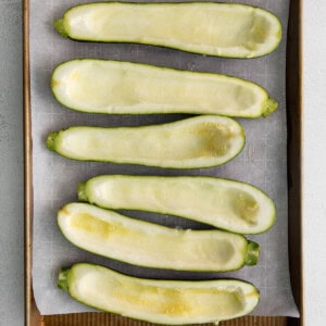 Sliced zucchini on a baking sheet.