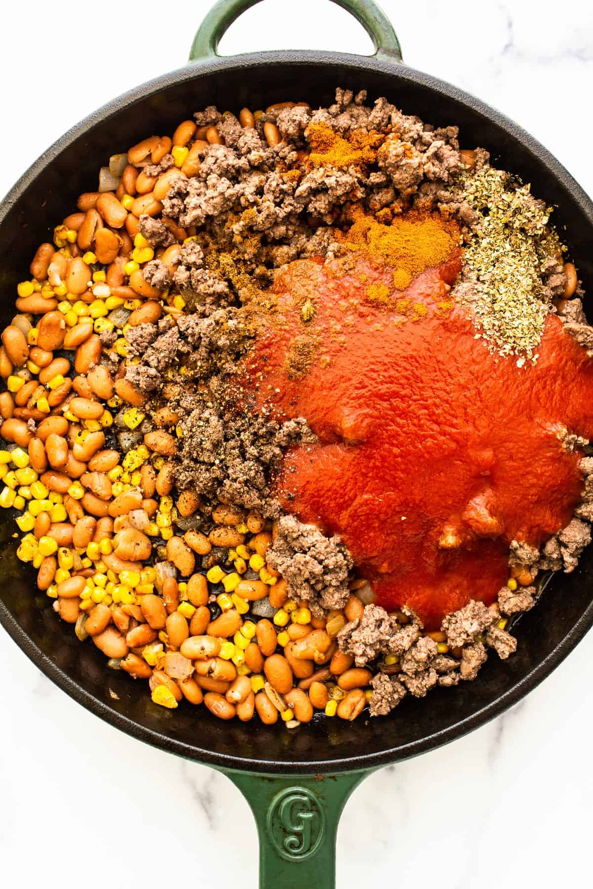 Ingredients for stuffed pepper filling in a cast iron skillet.