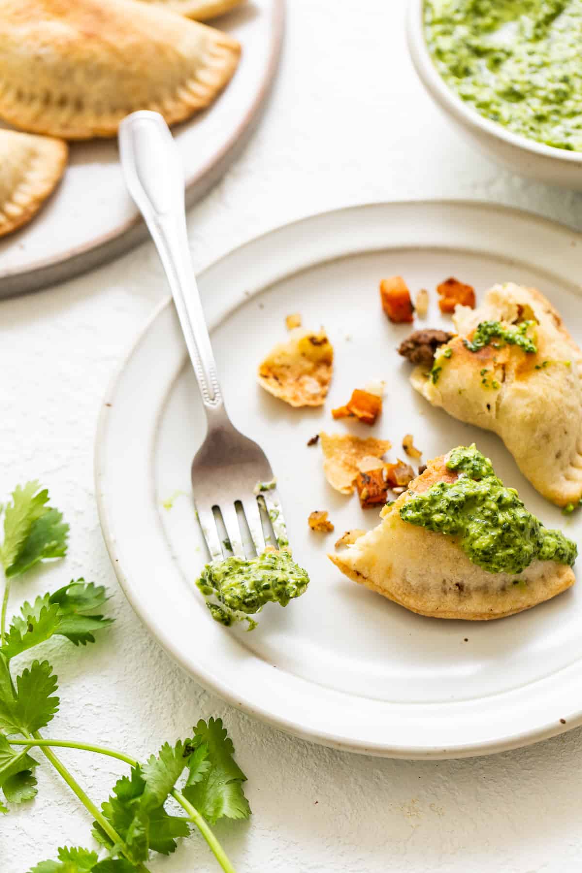 Empanadas with green sauce on top.