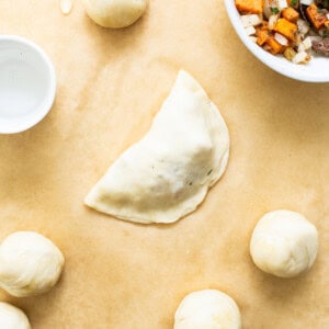 Sweet Potato Ground Beef Empanadas on parchment paper before baking.