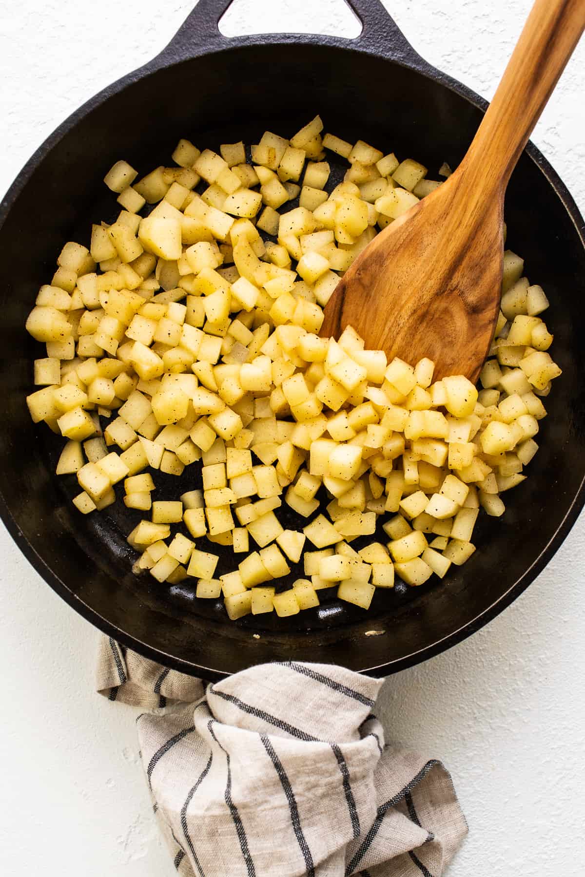 Honey crisp apples sauteing in a cast iron skillet.