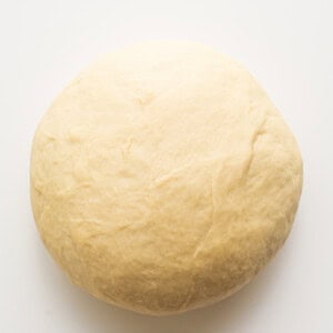 A ball of dough on a white surface.