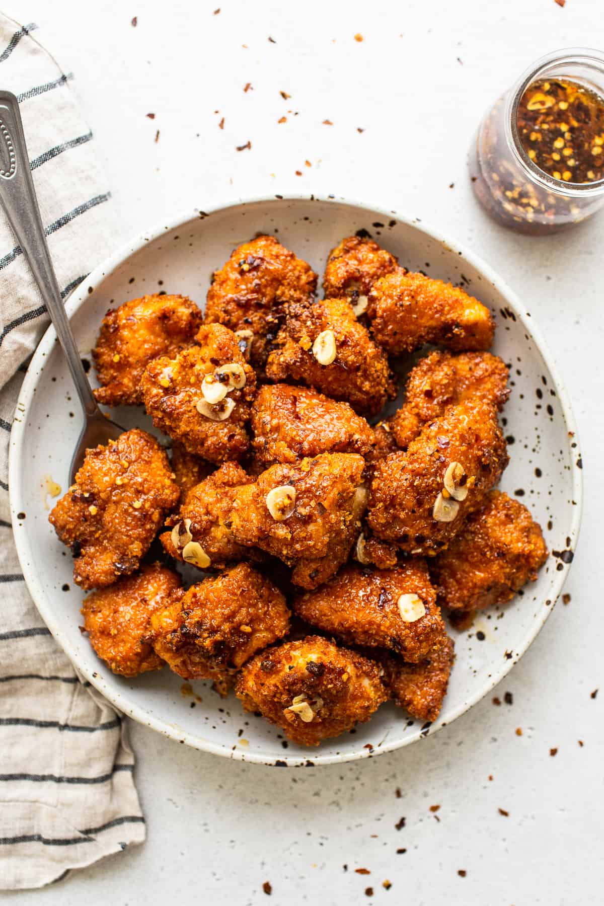 hot honey chicken in bowl with spoon.