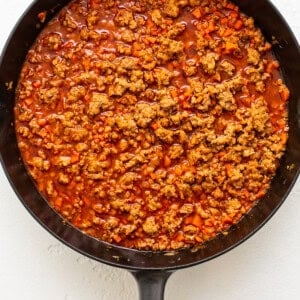 A skillet filled with meat and sauce.