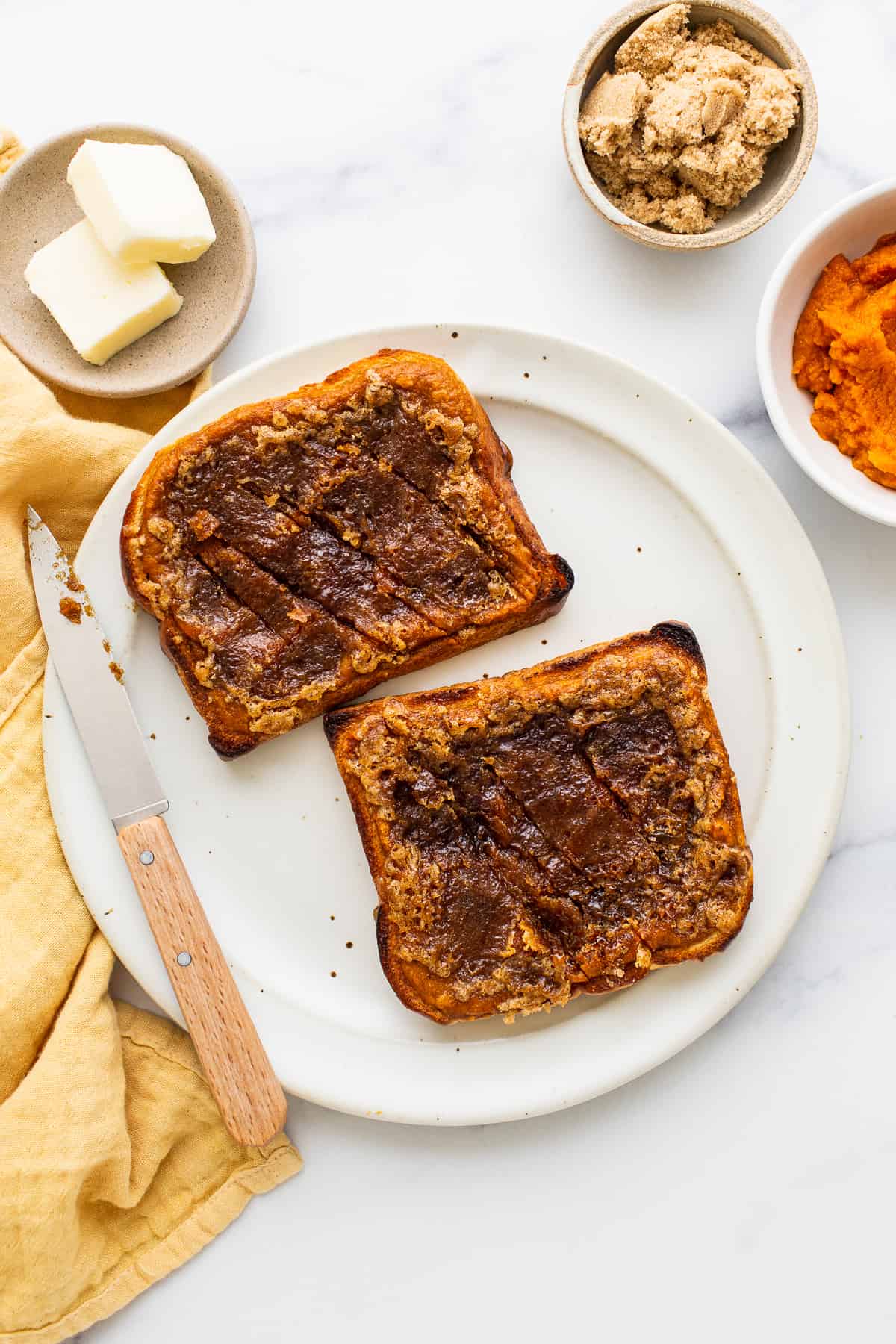 Pumpkin creme brulee french toast on a plate with a knife.