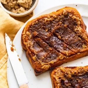 Two slices of toast on a plate with a knife.