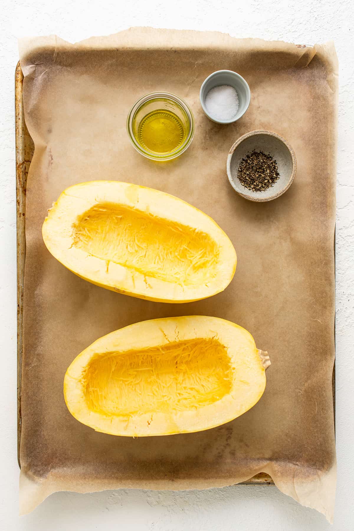 Spaghetti squash mac and cheese ingredients on a baking sheet.