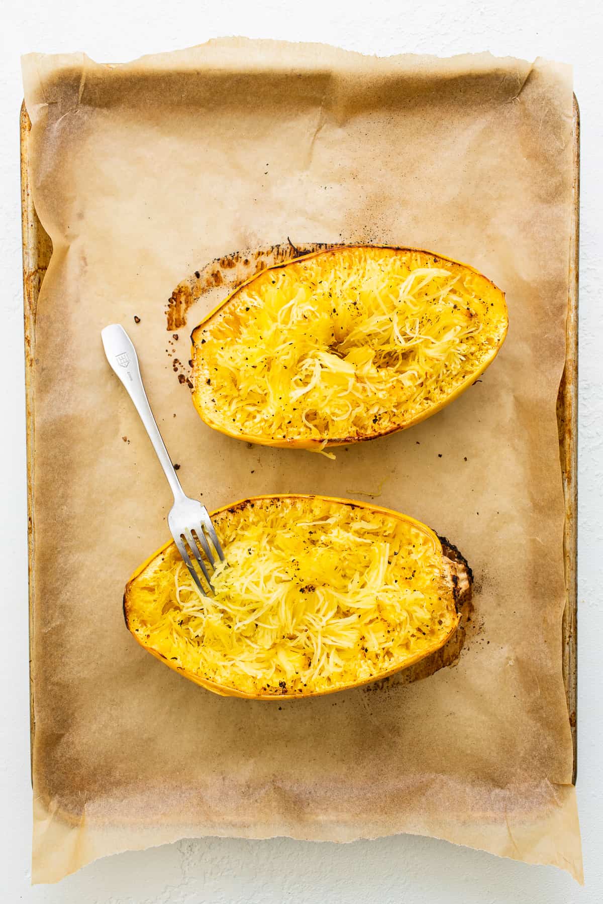 Spaghetti squash on a baking sheet.