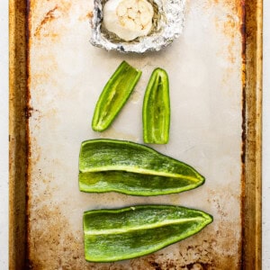 Peppers and garlic on a baking sheet.