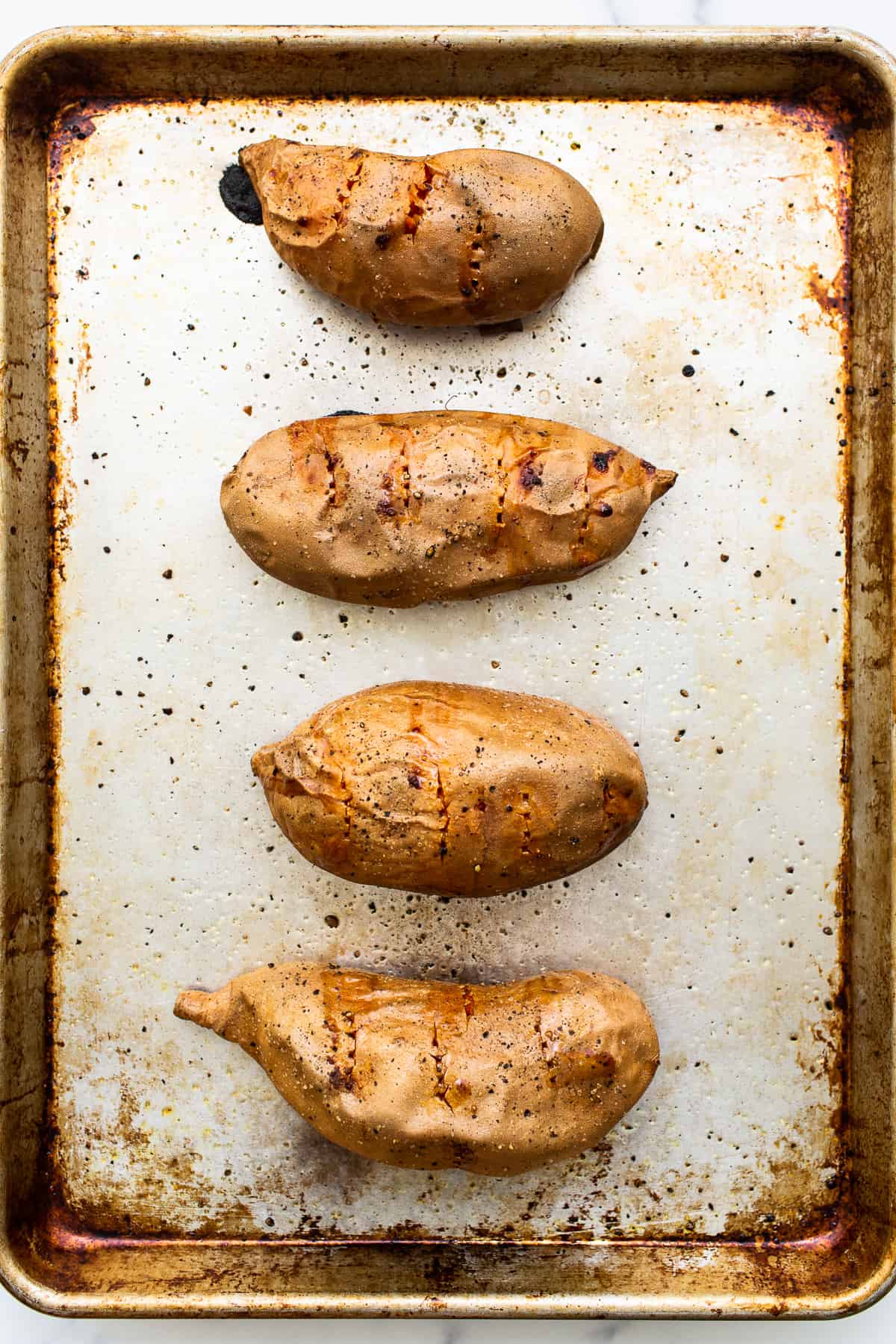 Baked sweet potatoes on a baking sheet.