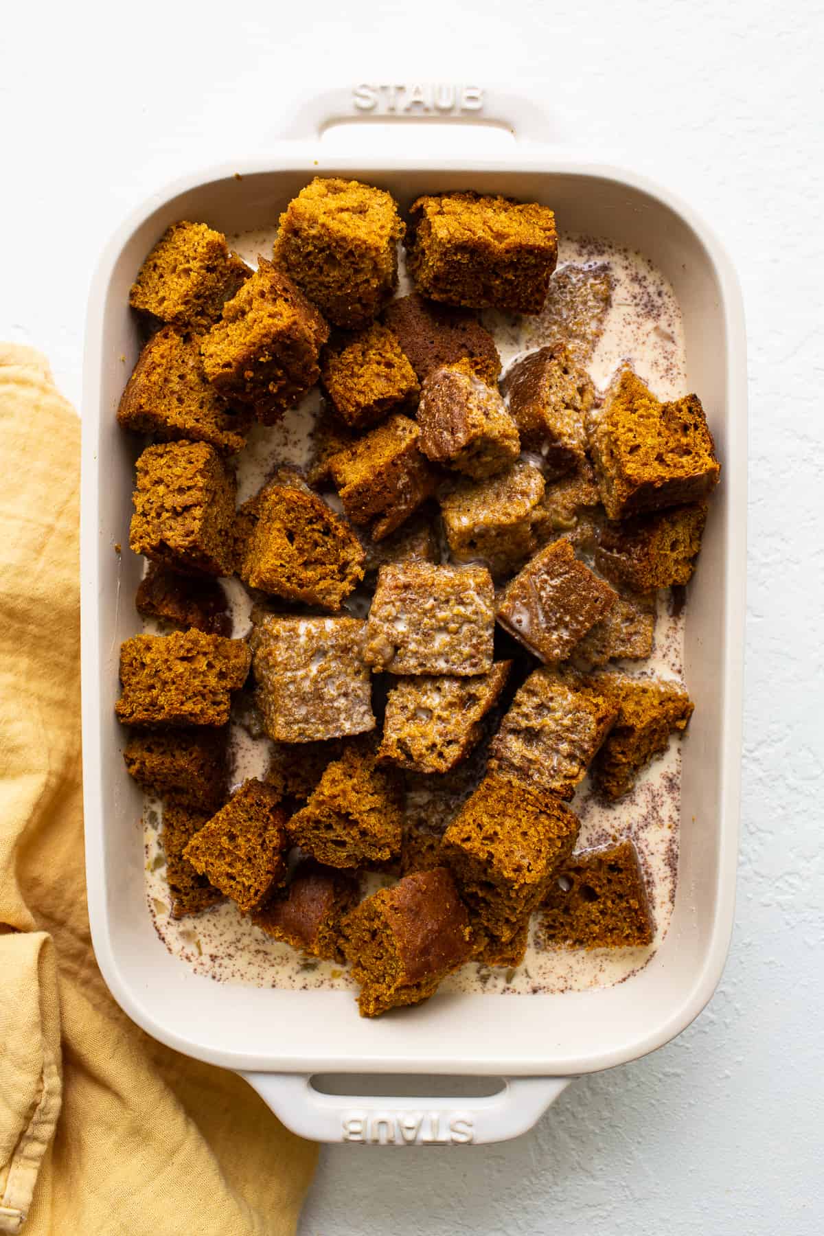 pumpkin bread pudding cubes soaking in egg.