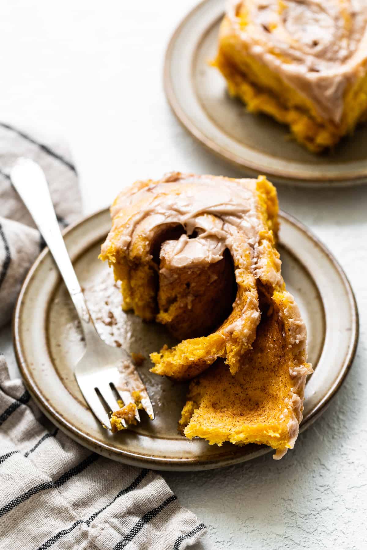 Pumpkin cinnamon roll on a plate.