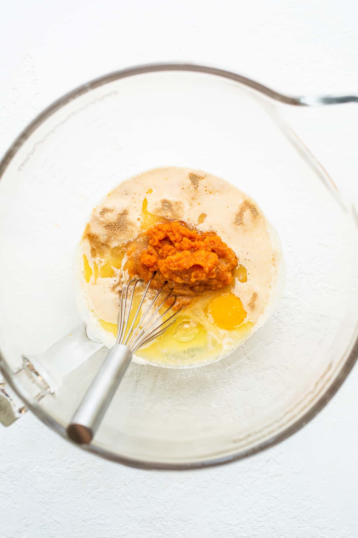 Wet ingredients for pumpkin cinnamon rolls in a bowl.