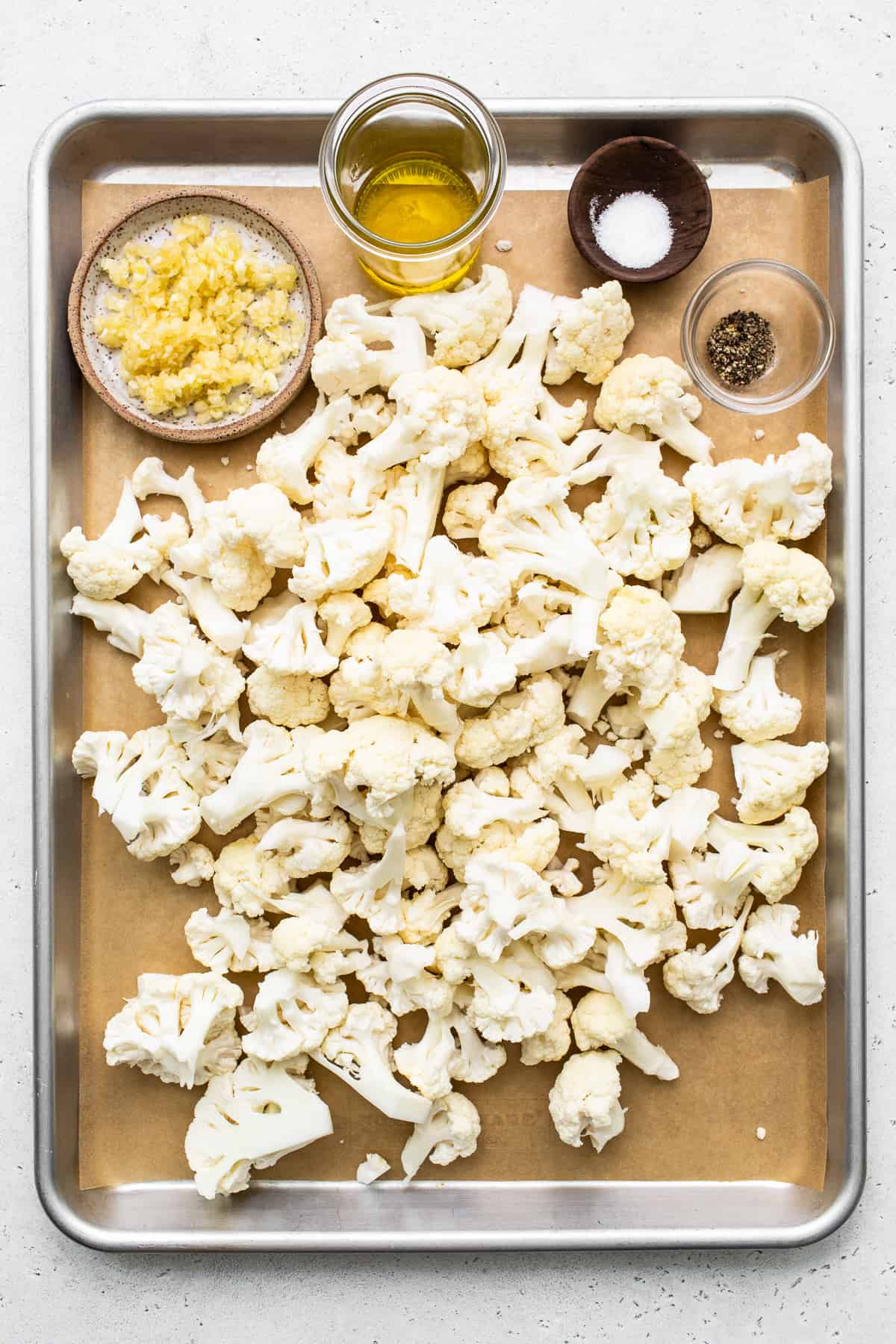 Cauliflower florets on a baking sheet.