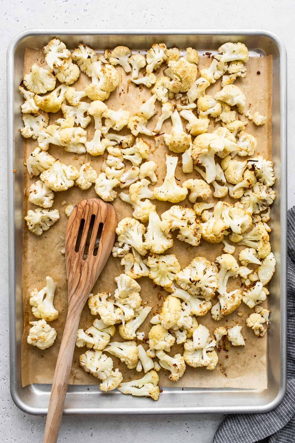 Cauliflower florets on a baking sheet.