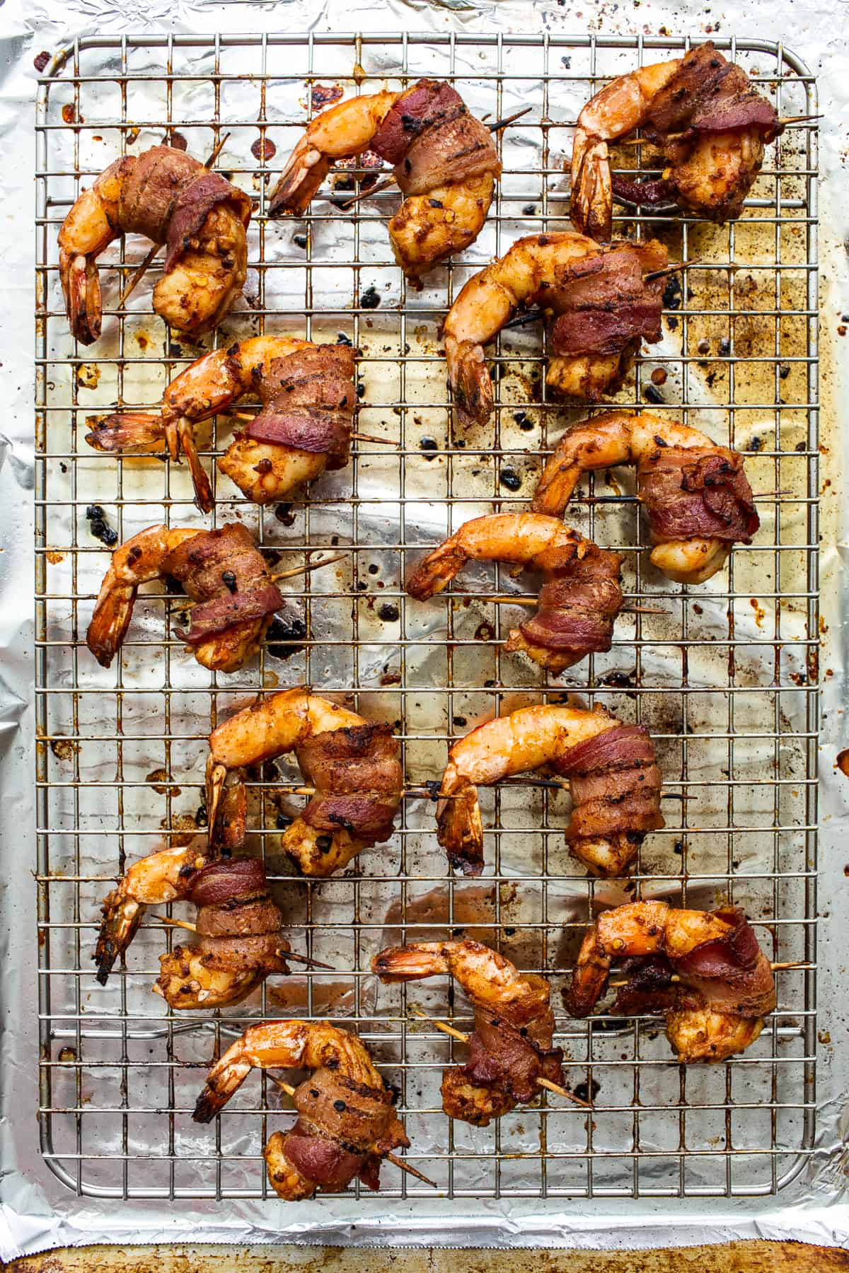 Bacon wrapped shrimp on a baking sheet.