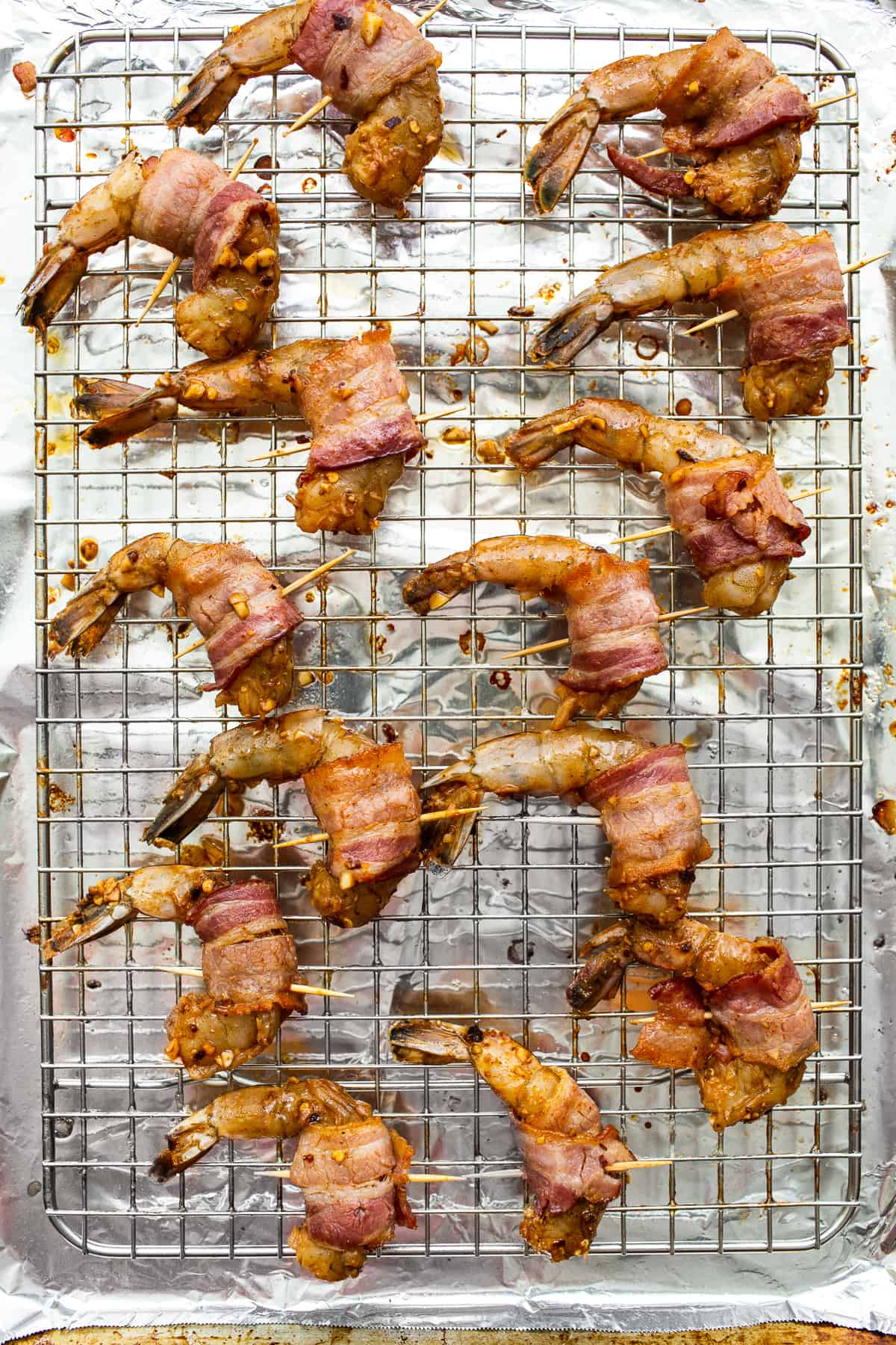 Bacon wrapped shrimp on a baking sheet.