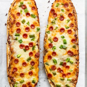 Two slices of pizza bread on a baking sheet.