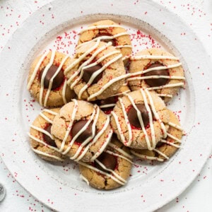 A plate of cookies with icing and sprinkles on it.