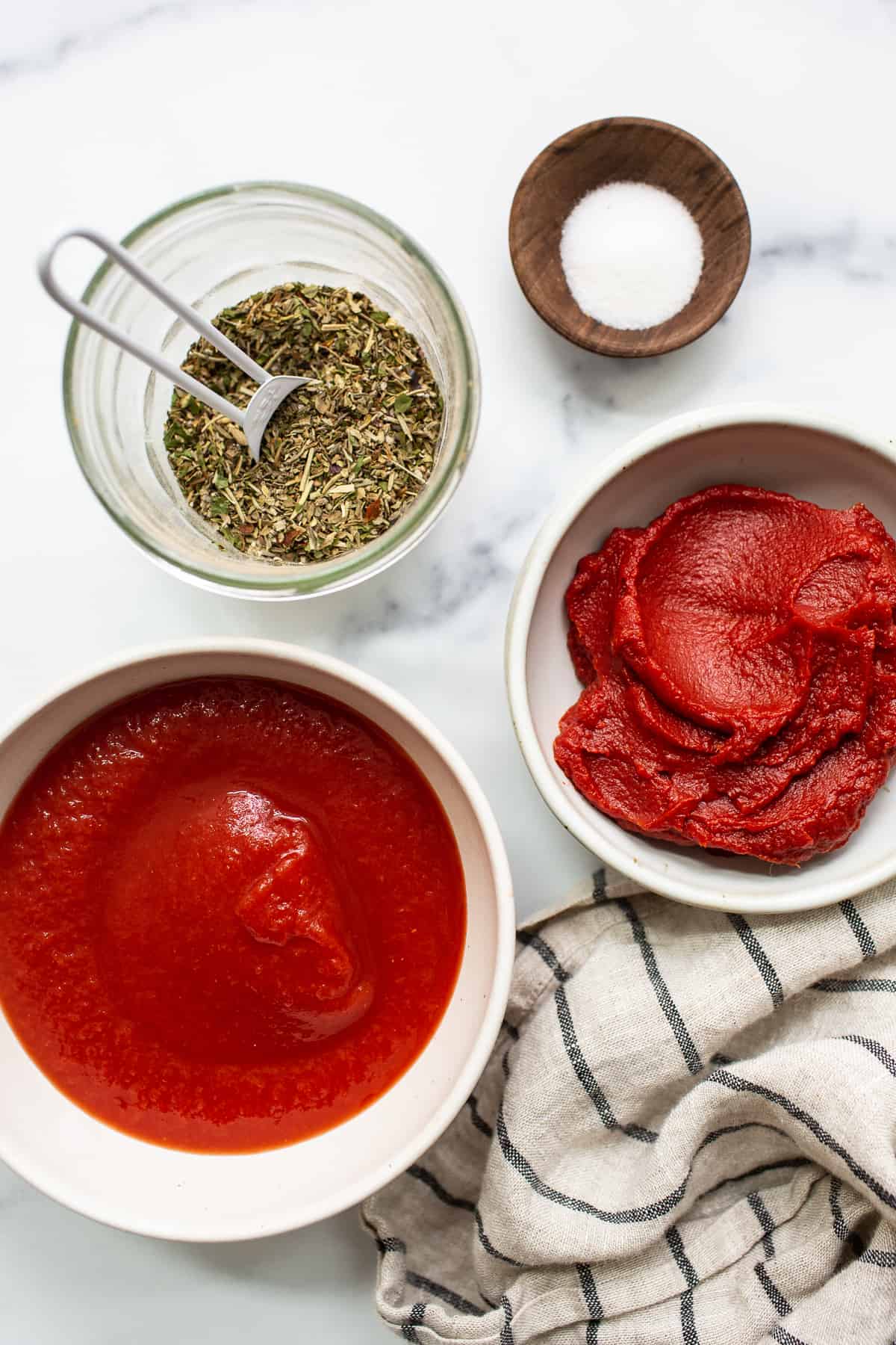 Ingredients for homemade pizza sauce in jars.