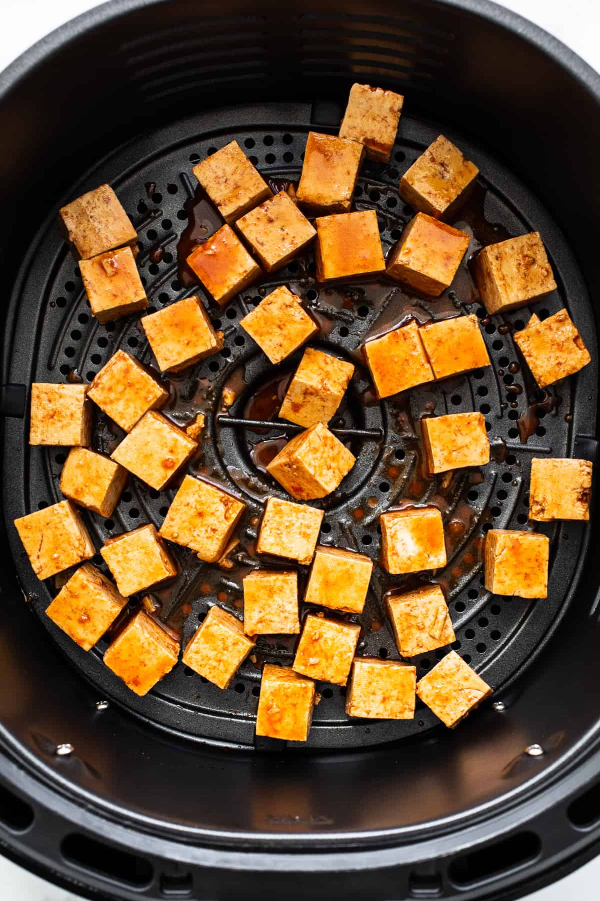 Placing the tofu in the air fryer.