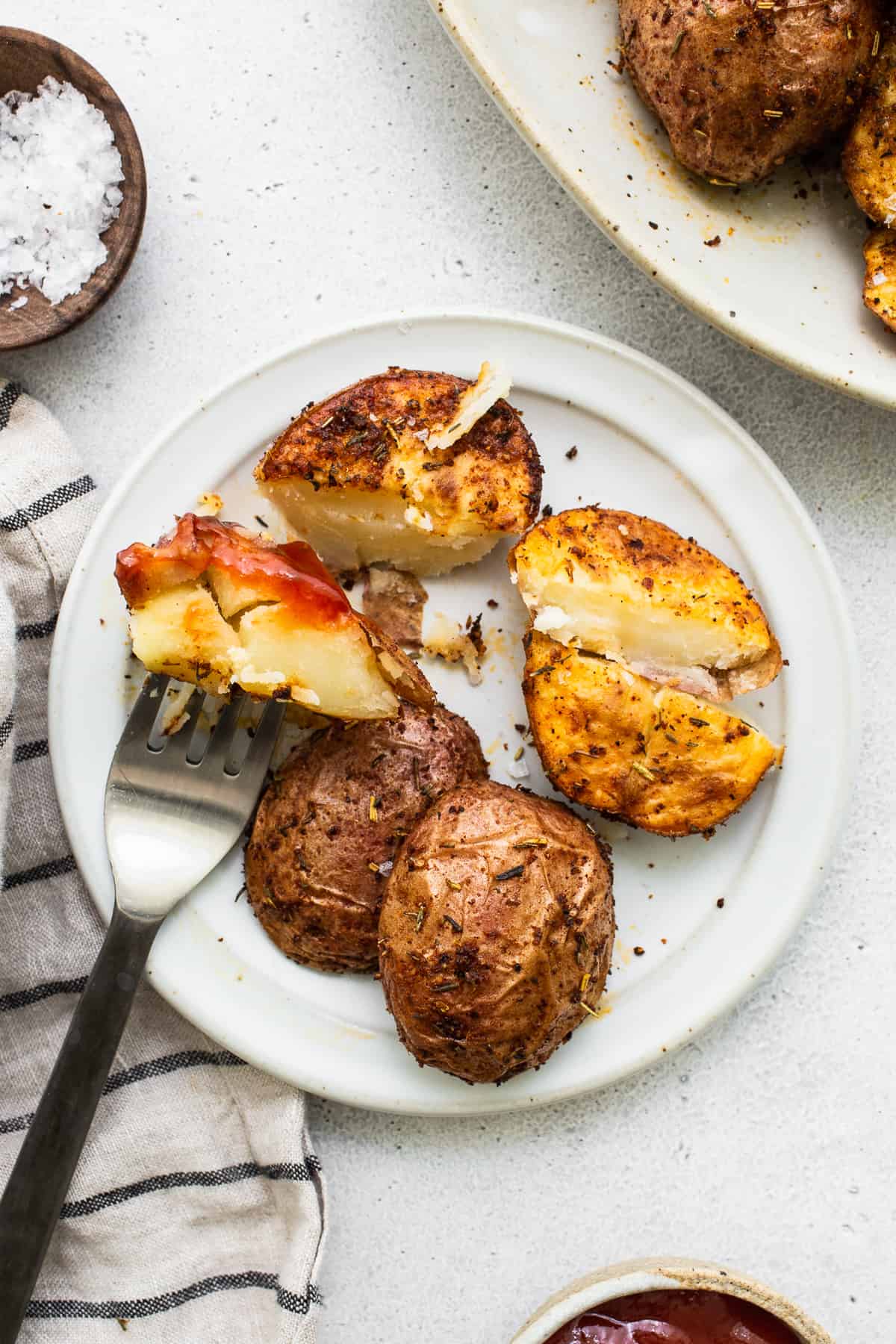 Air fryer potatoes with ketchup on a plate.