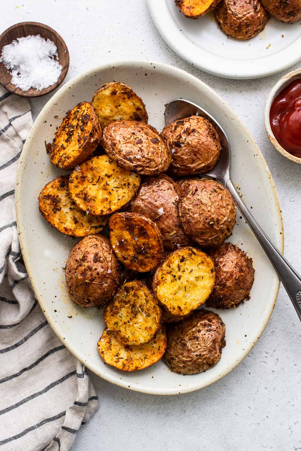 Air fryer potatoes on a plate with a spoon.