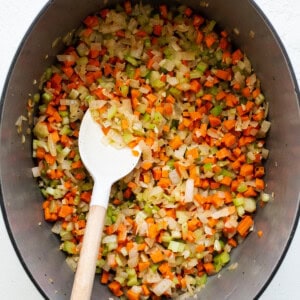 A pot with carrots and onions in it.