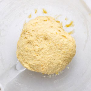 Orange roll dough in an oiled bowl.